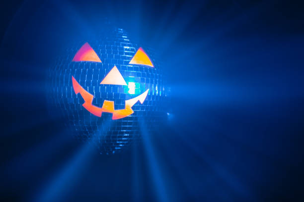 istock Halloween party pumpkin disco ball, jack-o-lantern with shiny rays in smoke 1280501946