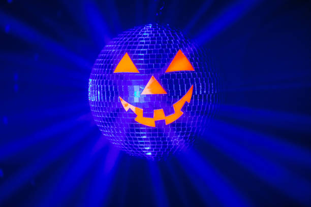 istock Halloween party pumpkin disco ball, jack-o-lantern with shiny rays in smoke 1280502001