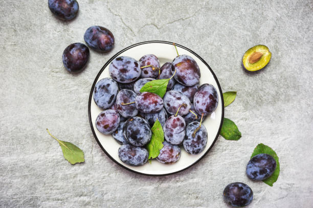 istock Ripe blue plums on a plate 1280502170