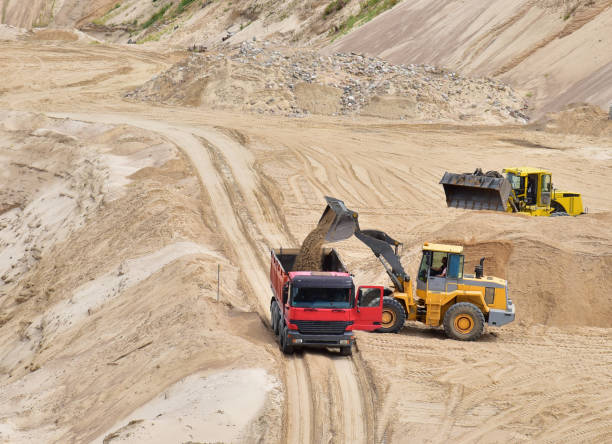 istock Wheel loader loading sand into heavy dump truck at the opencast mining quarry 1280503929