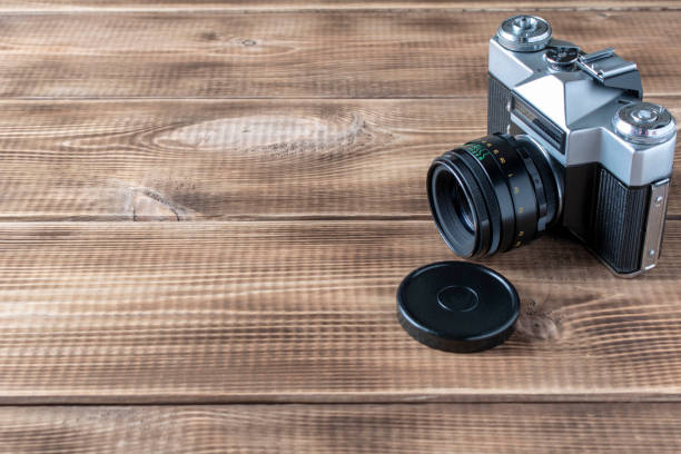istock Old retro camera on a wooden background. Close up. Selective focus. 1280503932