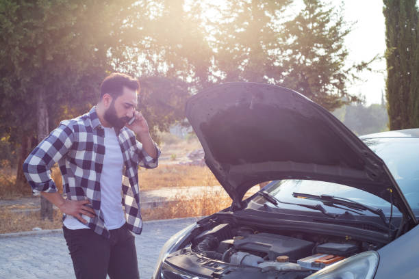 istock Young man with a broken car on the road 1280505254