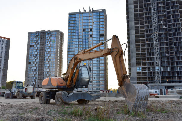 istock Bucked wheel excavator digs ground at a construction site. Backhoe the digging pipeline ditch 1280505580