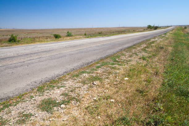 istock Roadside of an empty rural highway is under blue sky 1280506482