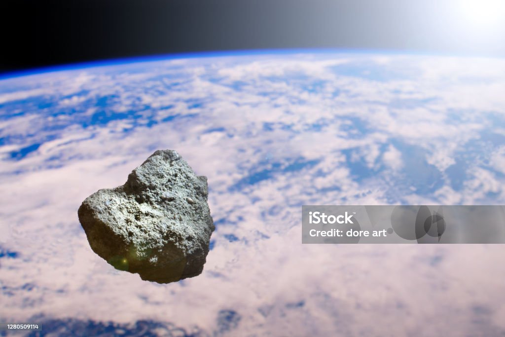 Asteroid on the background of the planet earth. Terrible Armageddon or the end of the world. Flying celestial body in the solar system. Threat and danger from space for the planet. An astronomical object is approaching the earth's orbit. Asteroid Stock Photo