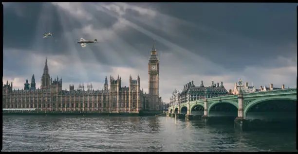 A classic Mk 1 Spitfire flies over the BritishParliament building. Model photography, composite image.