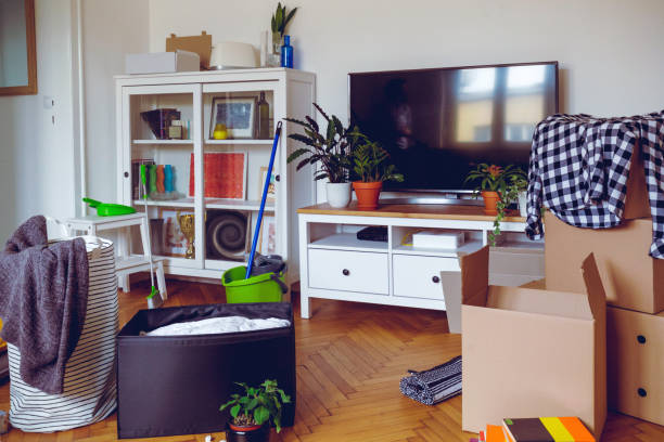 istock Unpacked boxes on the floor, TV on the stand by the showcase cupboard 1280509737