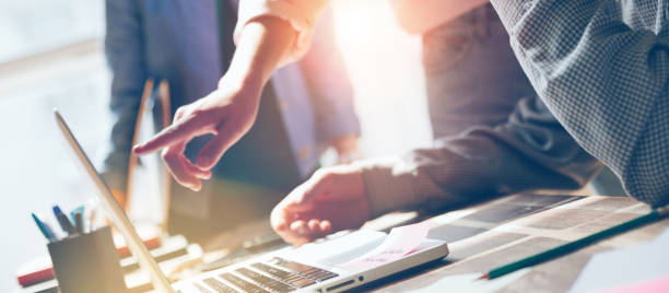 istock Business idea discussing. Startup team working with digital project. Laptop and paperwork on the table. Lens flares effect, film effect 1280510431