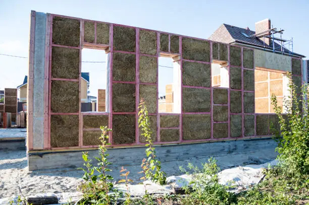 Photo of Construction of a house from an environmentally friendly material of plant origin. Frame made of wood, blocks of straw.