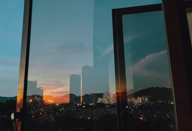 istock sunset looking through window at city with reflection on window with sunset sun 1280513529