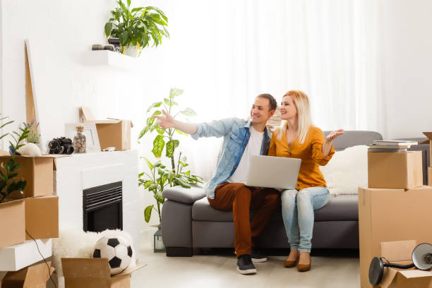 istock couple moving in together relaxing on sofa couch with laptop computer and boxes 1280515975
