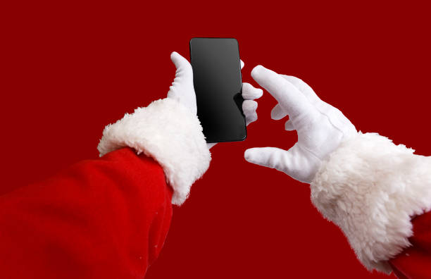 istock Santa Claus hands checking his smartphone with red background. 1280527644