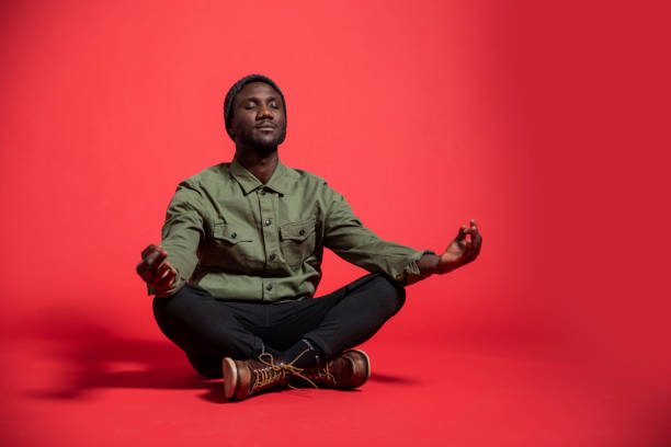 istock Young Black Man Meditating on Isolated Background 1280528123