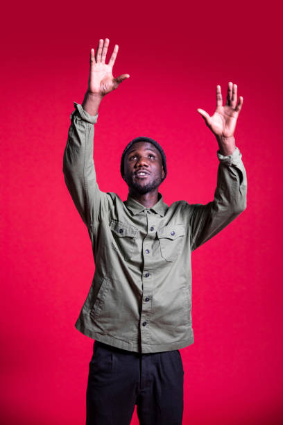 istock Young Black Man Reaching Up on Isolated Background 1280531129