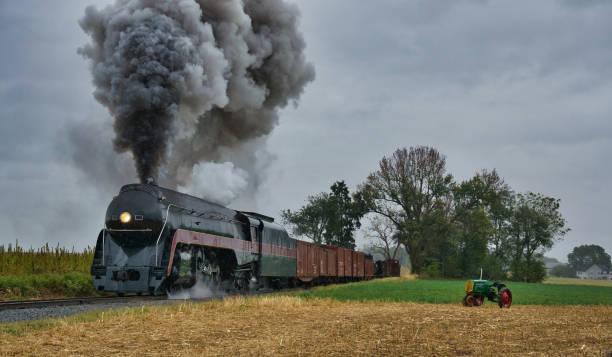 istock Antique restored steam engine puffing passed a restored antique tractor 1280534067