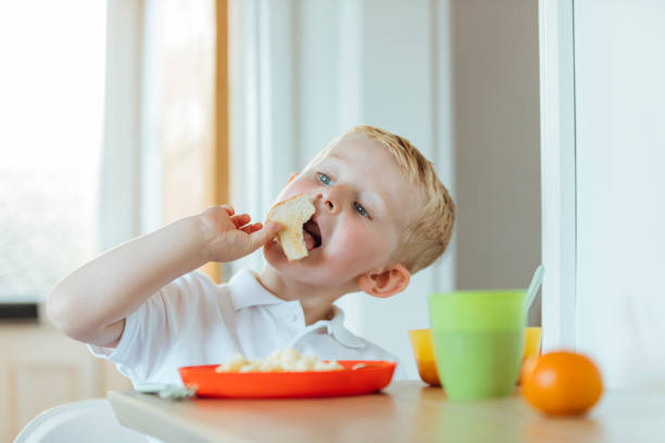 istock Young Boy in School Uniform Eating his Breakfast 1280535537