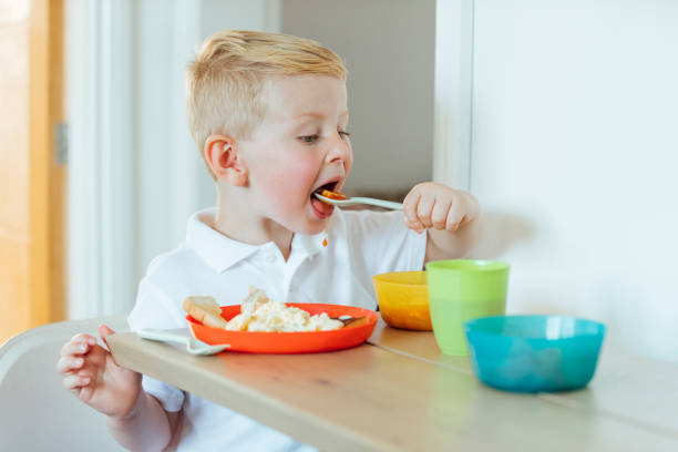 istock Young Boy Eating His Breakfast Whilst Wearing his Uniform 1280535635