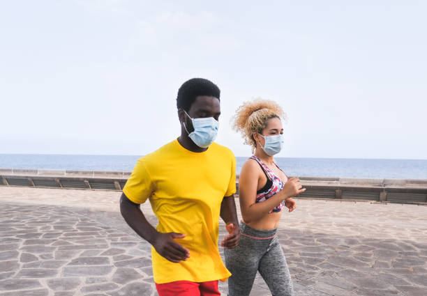 istock Multiracial couple doing sport outdoor while wearing protective face mask for coronavirus 1280536006