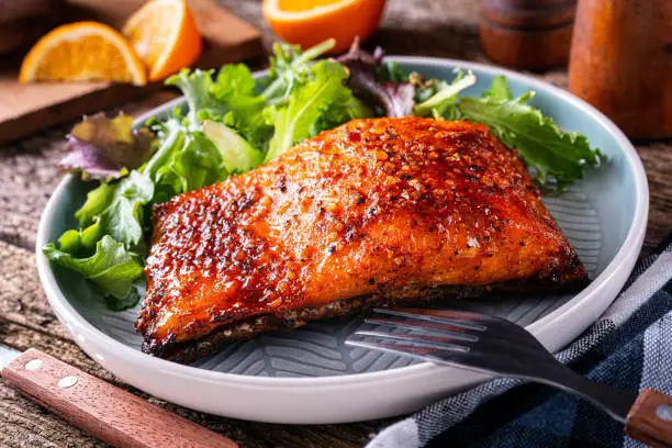 Delicious orange and ginger glazed planked salmon with side greens.