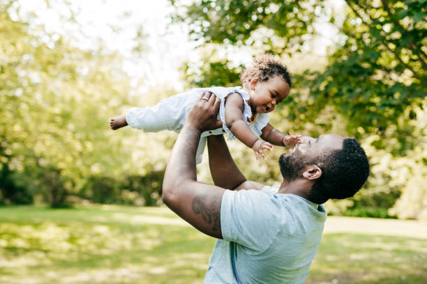 istock Dad playing with baby daughter in the park 1280546644