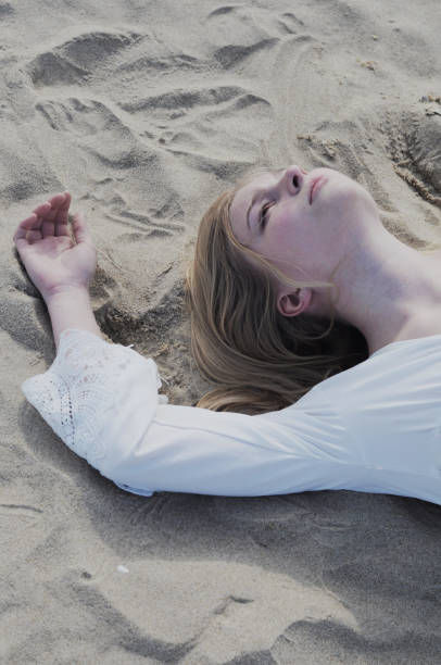 istock Young beautiful girl lying on a sand on a beach 1280547084