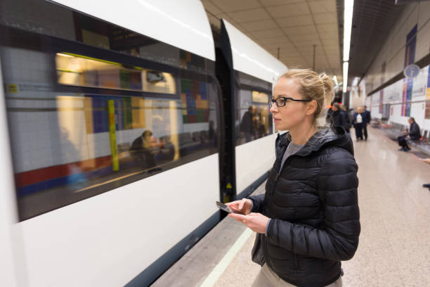 istock Side View Of Woman Using Smart Phone Standing At Railroad Station Platform 1280548090