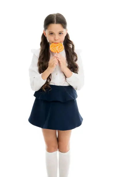 Healthy nutrition diet. Girl pupil school uniform like sweets lollipop candy white background. Sweets reward for study. Rewarding herself with sweets. Food addictions. Girl kid eat sweet lollipop.