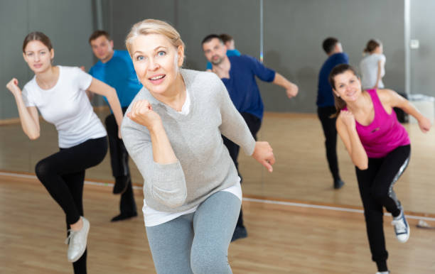 femme d’âge moyen exerçant au cours de danse - fitness dance photos et images de collection