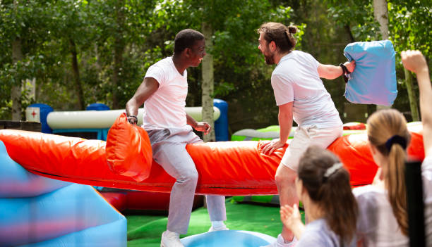 istock Cheerful pillow fight sitting on a log in an amusement park 1280557244