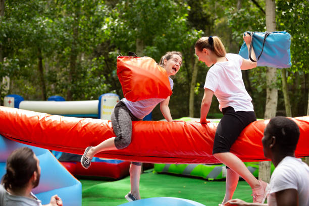 istock Women fighting by pillows on inflatable beam 1280557257