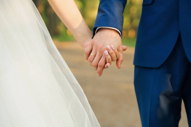 istock wedding couple holding hands. Hands close up 1280568929