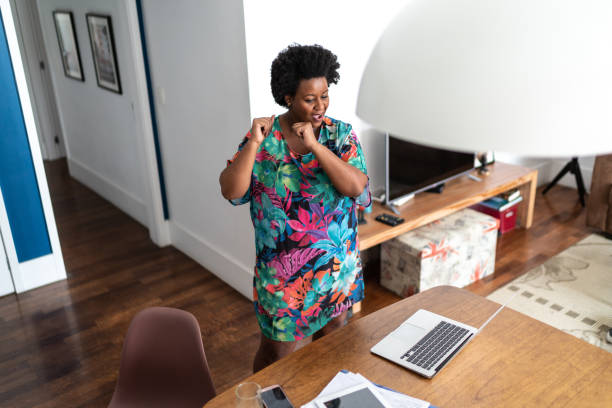 istock Happy woamn dancing at home in front of laptop during a virtual happy hour 1280570558