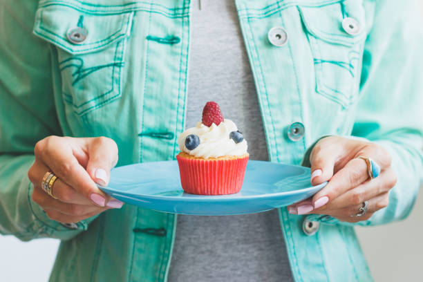 istock Woman with a cupcake on the plate 1280573383