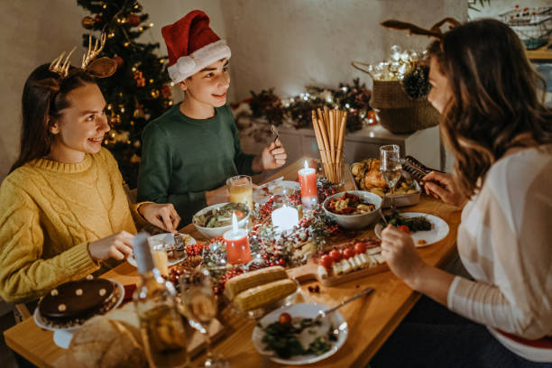 istock Mother with children enjoying Christmas dinner at dining table 1280573564