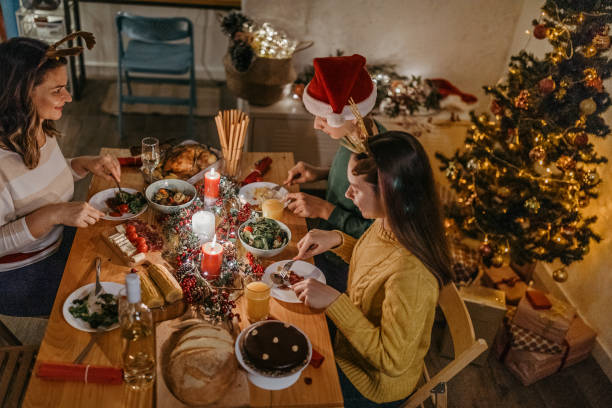istock Mother with children enjoying Christmas dinner at dining table 1280573883