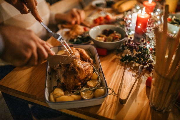 mann serviert gebratenes huhn zu frau während des weihnachtsessens - roast chicken chicken roasted food stock-fotos und bilder