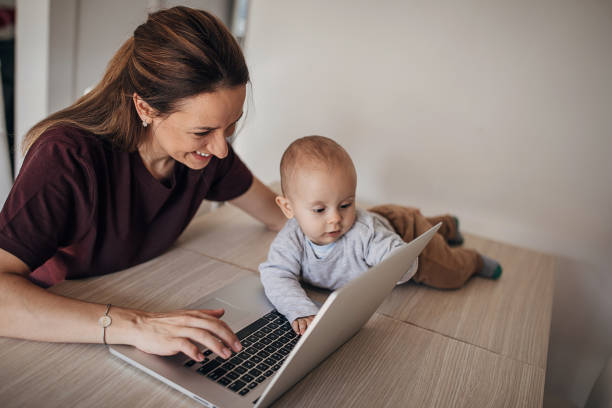 istock Young mother using laptop while her baby son interferes her 1280596874