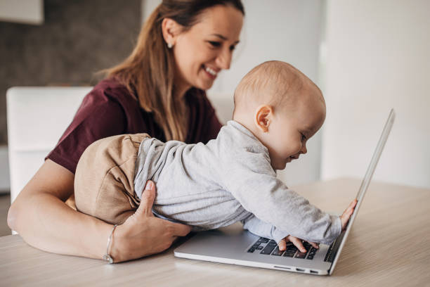 istock Mother using laptop while her baby boy interferes her 1280597282