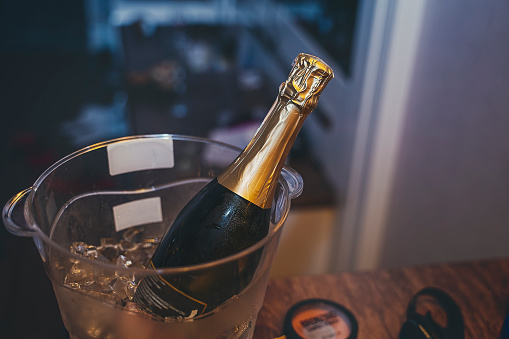 Cold bottle of champagne on ice with white background