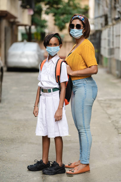 istock Indian school girl going to school campus while wearing protective face Mask for protection from COVID-19. 1280599403