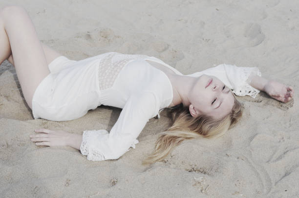 istock Young beautiful girl lying on a sand on a beach 1280602371
