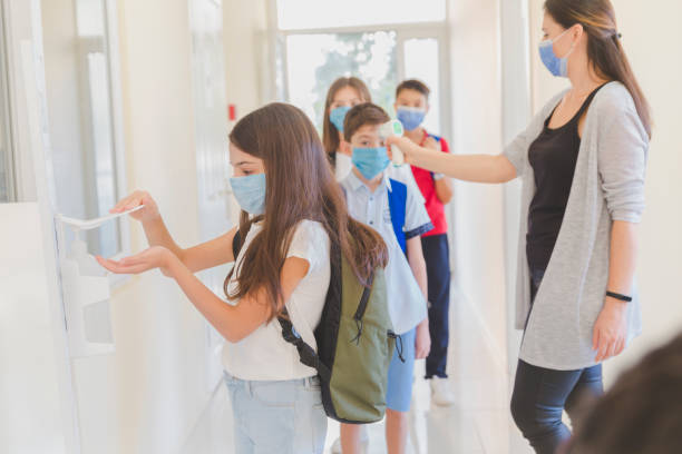 istock Little girl disinfecting hands while entering school. 1280613955
