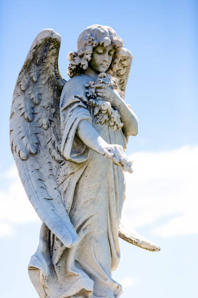 istock Angel, old statue of angle with flowers, background with copy space 1280618652