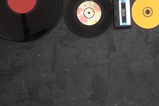 istock Musical storage devices and copy space. Old audio cassette tapes, compact disc and vinyl record on white wooden background with text space. 1280622145