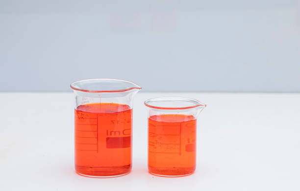 Beaker with color liquid. Solution chemistry. Laboratory beaker with colored liquid over white background.