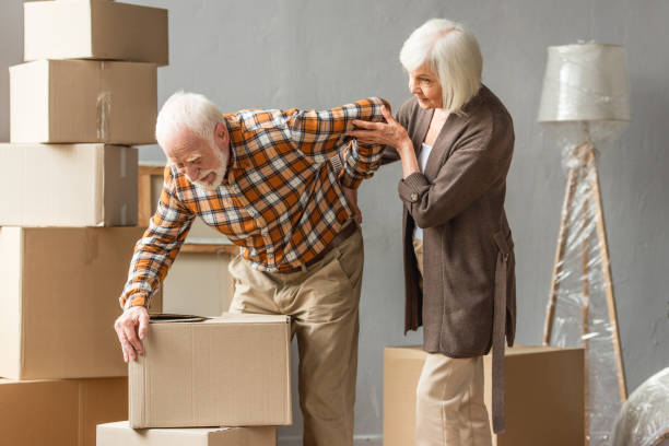 istock senior man suffering from backache and holding box while wife trying help 1280631014