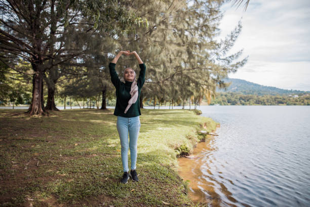 Asian women enjoy nature. She is standing and looking towards the lake.