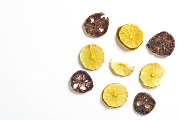 High angle view of 9 slice of dry lemons over white background.