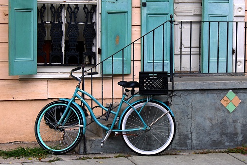 A green bicycle is parked near a shop window in St. George, Bermuda