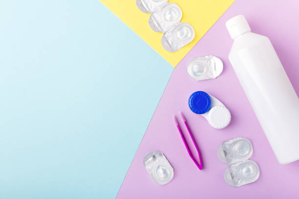 istock Contact lens kit with bottle of lens solution, case, tweezer on multicolor background, copy space, top view 1280643932